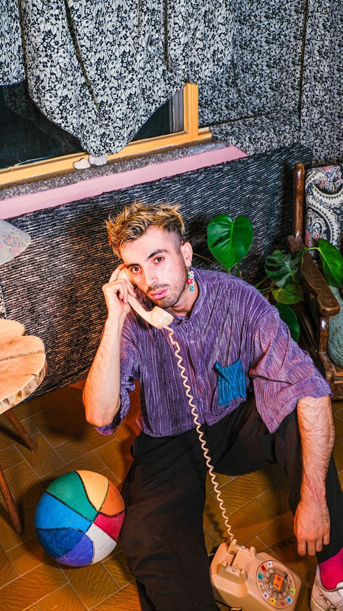 Man Sitting and Holding Toy Telephone Handset